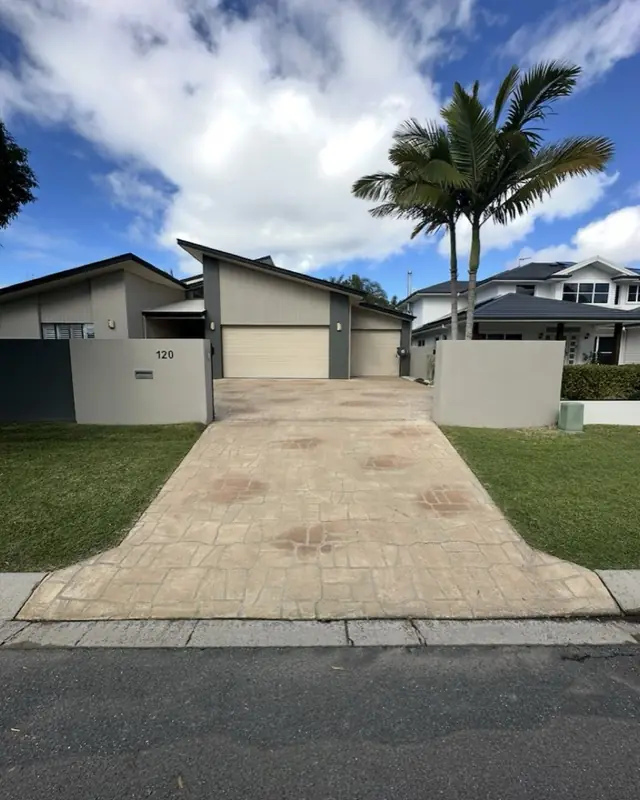 A clean stamped concrete driveway leading up to a home's garage